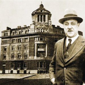 По-малкият и по-известен брат - политикът и банкер Атанас Буров, позира пред сградата на семейната банка в София, построена през 1921 г. от братята за централен офис на банката. След десетилетия тя ще стане собственост на КТБ