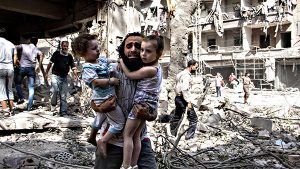 A Syrian man carries his two two girls a...A Syrian man carries