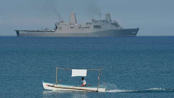 A Filipino fisherman is seen past the US Navy amphibious transport dock ship USS Green Bay (LPD-20) during an amphibious landing exercise on a beach at San Antonio in Zambales province on April 21, 2015, as part of annual Philippine-US joint maneuvers some 220 kilometres (137 miles) east of the Scarborough Shoal in the South China Sea. The Philippines voiced alarm April 20 about Chinese 