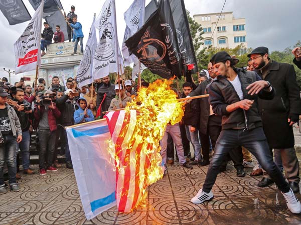 Palestinian protesters burn the U.S. and Israeli flags in Gaza City on Wednesday. President Trump is set to recognize Jerusalem as Israel's capital, upending decades of U.S. policy and ignoring dire warnings from allies.