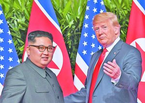 TOPSHOT - US President Donald Trump (R) gestures as he meets with North Korea's leader Kim Jong Un (L) at the start of their historic US-North Korea summit, at the Capella Hotel on Sentosa island in Singapore on June 12, 2018. Donald Trump and Kim Jong Un have become on June 12 the first sitting US and North Korean leaders to meet, shake hands and negotiate to end a decades-old nuclear stand-off. / AFP PHOTO / SAUL LOEB